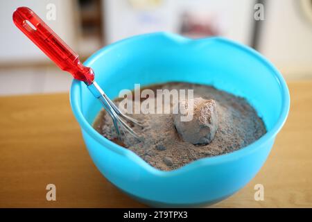 Einen Schneebesen in einer blauen Schüssel Mehl-Muffin-Mischung Stockfoto