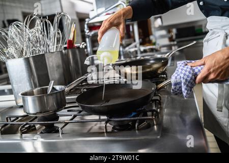 Kochen Sie Öl in eine beheizte Pfanne in einem Restaurant. Bild des Kochkonzepts des Luxushotels. Stockfoto