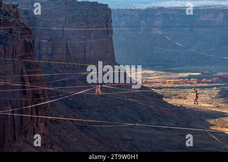 Zwei Personen auf Highlines beim GGBY World Highline Festival 500 Meter über dem Mineral Canyon in der Nähe von Moab, Utah. Stockfoto