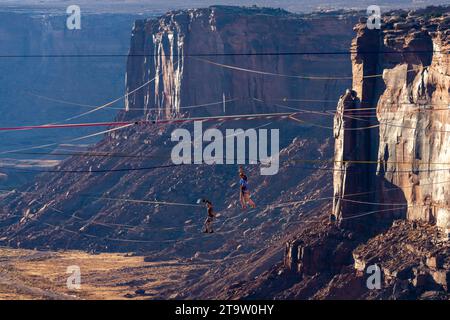 Zwei Personen auf Highlines beim GGBY World Highline Festival 500 Meter über dem Mineral Canyon in der Nähe von Moab, Utah. Stockfoto