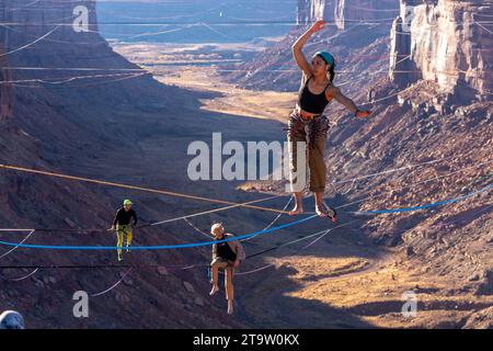 Drei Personen auf Highlines beim GGBY World Highline Festival 500 Meter über dem Mineral Canyon in der Nähe von Moab, Utah. Stockfoto