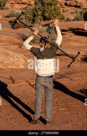 Ein junger Mann übt mit einem Feuerdrachen beim GGBY Highlining Festival in Moab, Utah. Er rollt den Stab über seinen Arm und über seine Sho Stockfoto