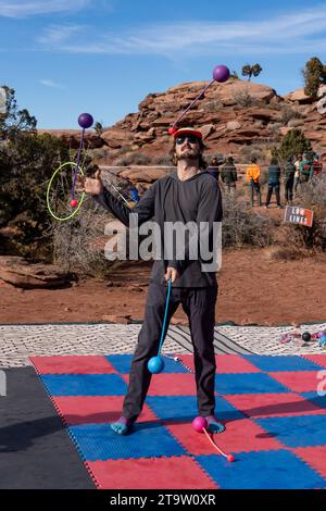 Ein Teilnehmer des GGBY Highlining Festivals übt sein Jonglieren, während er nicht durch die Highlines geht. Moab, Utah. Stockfoto