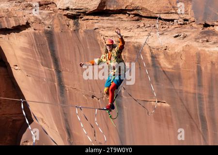 Ein junger Mann, der beim GGBY World Highline Festival im Mineral Canyon bei Moab, Utah, eine Highline durchläuft. Stockfoto