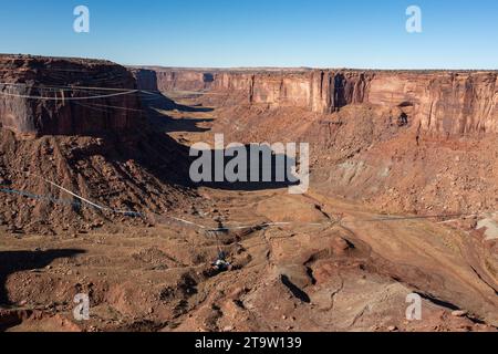 Aus der Vogelperspektive eines jungen Mannes, der 500 Meter über dem Boden des Canyons von einer Highline fällt, beim GGBY Highline Festival in der Nähe von Moab, Utah. Stockfoto