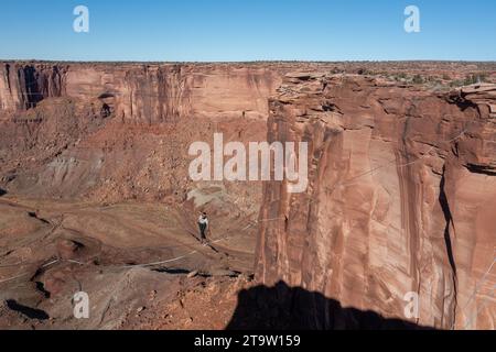 Aus der Vogelperspektive sehen zwei Personen, die 500 Meter über dem Boden des Canyons beim GGBY Highline Festival in der Nähe von Moab, Utah, hervorragen. Stockfoto