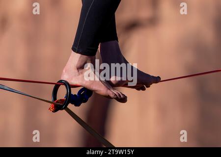 Eine junge Frau, die beim GGBY World Highline Festival im Mineral Canyon bei Moab, Utah, eine Highline durchläuft. Stockfoto