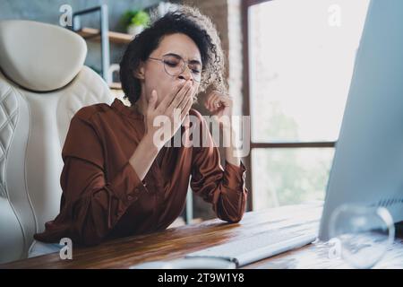 Porträt der müden überladenen Corporate Lady Sitting Stuhl Hand Cover Mund Gähnen Loft Innenraum Büro innen Stockfoto
