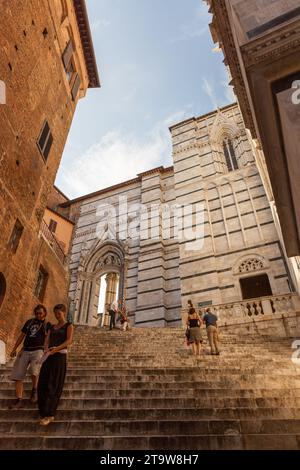 Fußgänger auf den Stufen der Treppe, die zur Kathedrale von Siena führt. Piazza del Duomo, 8, 53100 Siena SI, Italien Stockfoto