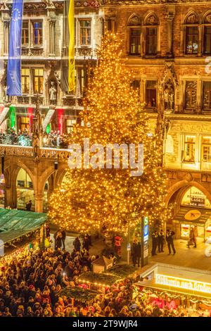 Münchner Christbaum mit Festbeleuchtung, Eröffnung Münchner Christkindlmarkt auf dem Marienplatz, 27. November 2023 Deutschland, München, 27.11.2023, Eröffnung des Münchner Christkindlmarkts auf dem Marienplatz, wurde mit dem Einschalten der Lichter am Münchner Weihnachtsbaum eröffnet, eine 25 Meter hohe serbische Fichte aus Königsdorf, Landkreis Bad Tölz-Wolfratshausen, Blick auf das Rathaus, Vogelperspektive, von oben, Lichterglanz, Weihnachtszeit, Weihnacht, Weihnachtsbaum, leuchten, festlich, Menschenmenge, Adventszeit, Adventszeit, Abend, Dunkelheit, Zentrum, November 2023, Tradition, Bayern, Stockfoto