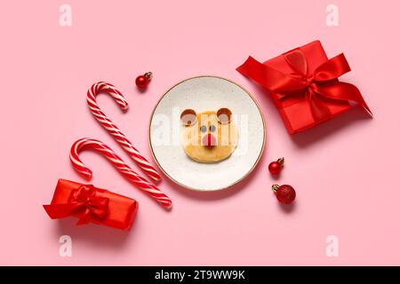 Teller mit Pfannkuchen in Bärenform auf rosa Hintergrund. Weihnachtsfeier Stockfoto