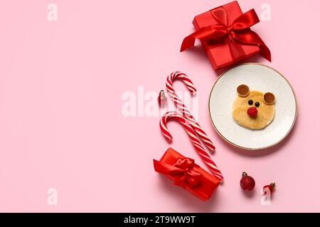 Teller mit Pfannkuchen in Bärenform auf rosa Hintergrund. Weihnachtsfeier Stockfoto