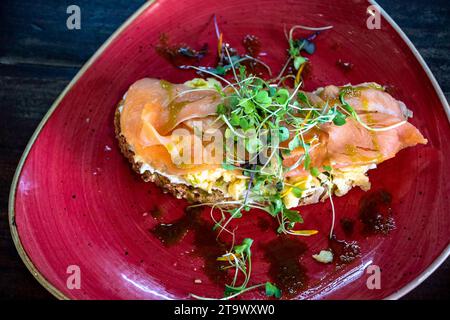 Aus der Vogelperspektive sehen Sie eine Scheibe Toast mit Rührei und Räucherlachs aus nächster Nähe. Stockfoto