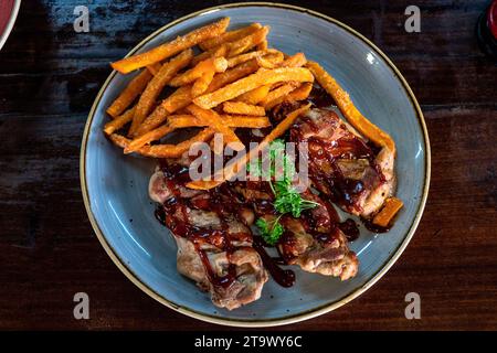 Frisch gegrillter Hähnchenschenkel mit Süßkartoffel-Pommes. Stockfoto