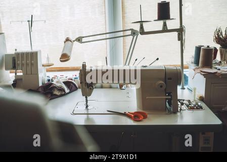 Näherin-Arbeitsplatz. Nähmaschine und diverses Zubehör. Stockfoto