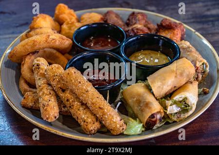 Ein Nahbild einer gemischten Vorspeise-Kombo-Platte, serviert mit eintauchenden Saucen. Stockfoto