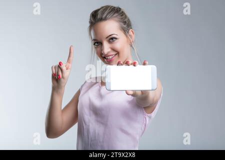 Technikfreundliches Modell mit Mobiltelefon-Gesten für technologische Möglichkeiten Stockfoto