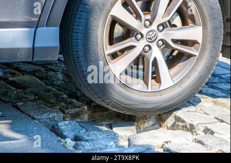 NEW ORLEANS, LA, USA - 15. SEPTEMBER 2023: Nahaufnahme der Radmontage und des Yokohama Geolandar-Reifens auf einer zerrissenen Kopfsteinpflasterstraße Stockfoto