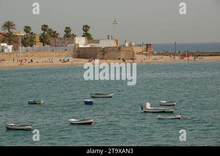 Blick auf den Strand von Cadiz, die Bastion von San Pedro und die Uferpromenade vom Inneren des Castillo de Santa Catalina in Cadiz, Spanien. Die pentagon-förmige Burg wurde gebaut, nachdem die Engländer 1596 die Stadt geplündert hatten, um die Bucht von Cadiz zu bewachen. Stockfoto