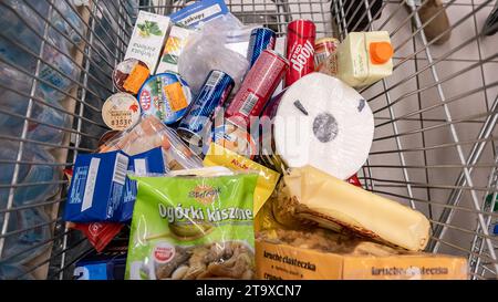 Ein Einkaufswagen voller verschiedener Lebensmittelprodukte aus der Perspektive eines Supermarktes mit Einkaufswagen-Inhalt von oben nach unten, Niemand, Poli Stockfoto