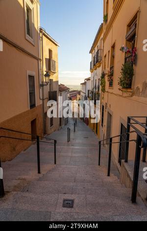 Wunderschöne Cuesta del Maestre Straße bei Sonnenuntergang mit typischen Häusern im alten Zwillingsviertel von Caceres, Weltkulturerbe von Stockfoto