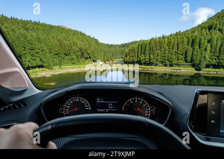 Fahrerblick auf eine Lagune mit wunderschöner Aussicht auf die grüne Landschaft aus einem angehaltenen Auto des Fahrers POV der Straßenlandschaft. Die Insel São Miguel im Azo Stockfoto