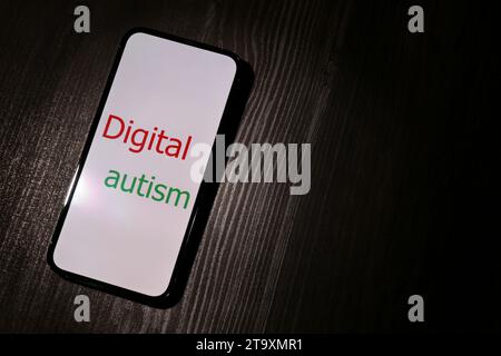 Suchtverhalten. Smartphone mit Phrase Digital Autism auf Holztisch, oben. Leerzeichen für Text Stockfoto