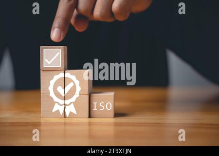 Der Finger eines Geschäftsmannes, der ISO-Holzwürfel drückt Stockfoto