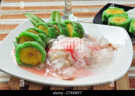 Es Pisang Ijo, traditionelles Dessert aus Makassar, Süd-Sulawesi, Indonesien, hergestellt aus Bananen, die mit einer Mischung aus Weizenmehl und Reisflou gerollt werden Stockfoto