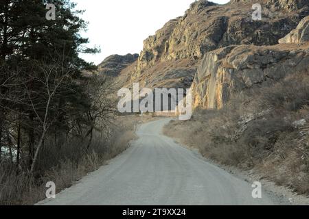 Eine staubige, unbefestigte Straße entlang der Bergkette führt über hohe Hänge. Altai, Sibirien, Russland. Stockfoto