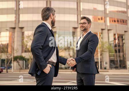 Das Bild von zwei Geschäftsleuten, die mit Handschlag zu tun haben. Zwei Geschäftsmänner geben sich die Hand. Stockfoto