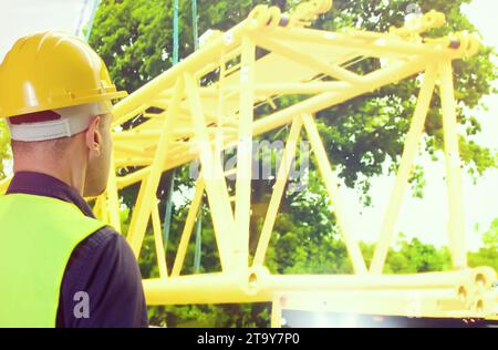 Rückansicht männlicher Bauarbeiter vor dem Bauen im Waldhintergrund. Stockfoto