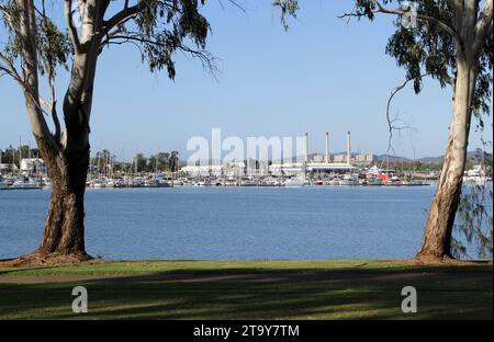 Blick auf die Boote an der Gladstone Marina mit dem Kraftwerk im Hintergrund in Queensland, Australien Stockfoto