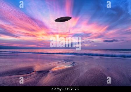 Eine unbekannte Flying Object Untertasse schwebt in Einem surrealen Himmel am Strand Stockfoto