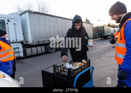 Medyka, Polen. November 2023. Ukrainische LKW-Fahrer erhalten Lebensmittel von einer NGO, während sie in einer Warteschlange warten, um die Grenze in Korczowa zu überqueren, während die polnische verkehrsgewerkschaft streikt und den LKW-Transport in Korczowa blockiert - Grenzübergang zwischen Polen und der Ukraine. Die Landwirte traten am 24. November dem Verkehrssektor bei, um gegen die schlechte Verwaltung der Agrarimporte ukrainischer Erzeugnisse zu kämpfen und um die Neuaushandlung von Transportabkommen zwischen der Ukraine und der Europäischen Union zu fordern. Medyka ist die vierte Stätte. Quelle: SOPA Images Limited/Alamy Live News Stockfoto