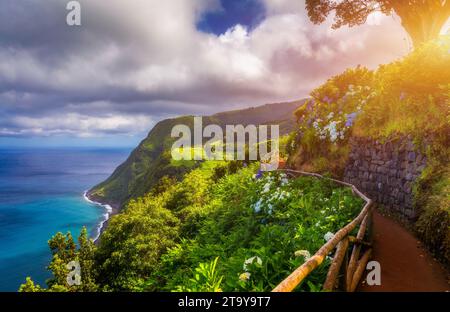 Aussichtspunkt Ponta do Sossego, Sao Miguel Island, Azoren, Portugal. Blick auf Blumen auf einem Berg und das Meer in Miradouro da Ponta do Sossego Nordeste Stockfoto