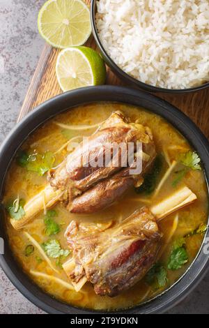 Nihari ist ein köstlicher, glatter Eintopf auf Mehlbasis mit langsam gekochtem Hammelfleisch und einer Vielzahl von Gewürzen, serviert mit Reisnähe auf dem Tisch. Vertikaler oberer Bildschirm Stockfoto