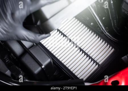 Wechseln des Fahrzeugluftfilters, schließen Sie den neuen und sauberen Luftfilter in der Hand des Technikers. Fahrzeugwartungskonzept. Stockfoto