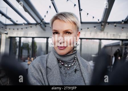 Selfie der schönen Reifen blonden Frau mit kurzem Haarschnitt in modernen trendigen Kleidern, grauem Rollkragen, Jacke. Nahaufnahme Porträt stilvoll Mittelalter fe Stockfoto
