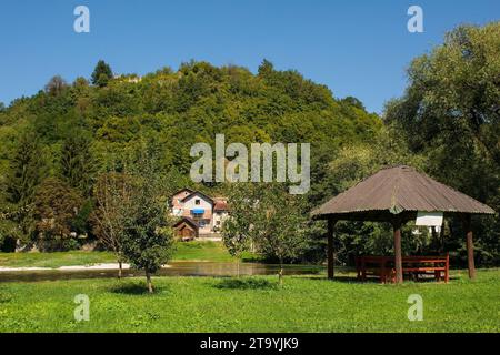 Fluss Una, der durch Kulen Vakuf im Una-Nationalpark fließt. Kanton Una-Sana, Föderation Bosnien und Herzegowina. Die Ruinen der Festung Havala auf dem Hügel Stockfoto