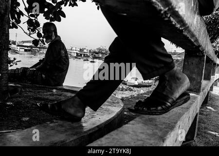 Traditionelle Frachtbootstation am Ufer. Eine malerische Szene entfaltet sich entlang des Flusses von Bangladesch, während traditionelle Frachtschiffe Th finden Stockfoto