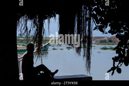 Traditionelle Frachtbootstation am Ufer. Eine malerische Szene entfaltet sich entlang des Flusses von Bangladesch, während traditionelle Frachtschiffe Th finden Stockfoto