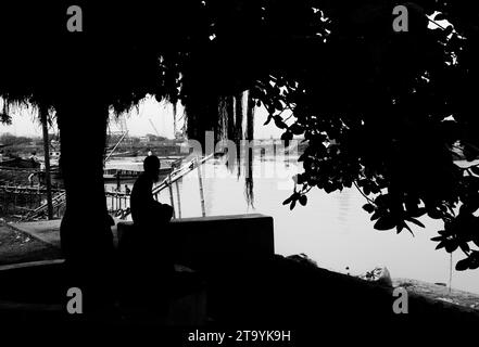 Traditionelle Frachtbootstation am Ufer. Eine malerische Szene entfaltet sich entlang des Flusses von Bangladesch, während traditionelle Frachtschiffe Th finden Stockfoto