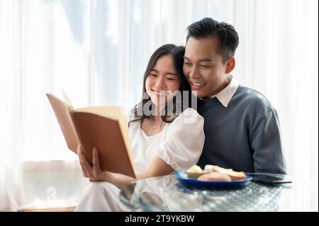 Das junge, hübsche asiatische Paar teilt ihre Freizeit zusammen und liest Bücher in einem süßen Café. Paarungskonzept. Stockfoto