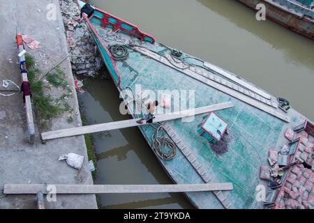 Traditionelle Frachtbootstation am Ufer. Eine malerische Szene entfaltet sich entlang des Flusses von Bangladesch, während traditionelle Frachtschiffe Th finden Stockfoto