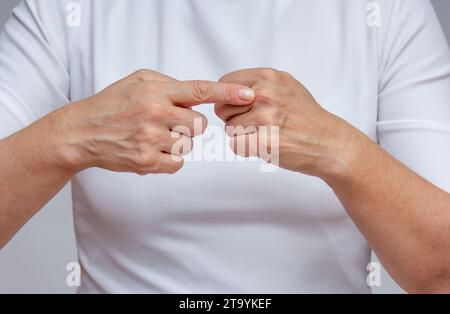 Frau Zeigefinger zeigt auf den zweiten digitalen Handgelenk, um Arthritis zu identifizieren Stockfoto