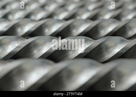 Satz von Stahlbohrern, spiralförmige Schneidkanten perspektivische Nahaufnahme, selektiver Fokus, abstrakter industrieller Hintergrund Stockfoto