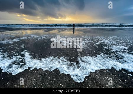 Goldenes Sonnenlicht, tief hängende Regenwolken und eintretende Flut an einem dezembernachmittag an der Nordseeküste auf der Insel Rømø Stockfoto