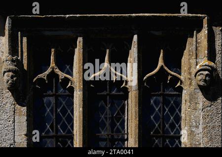 Rechtwinkliges gotisches Kirchenfenster der St. Mary’s Church im Dorf Little Coxwell im Vale of the White Horse, Oxfordshire, England. Die Kirche wurde in den 1100er Jahren erbaut Dieses Fenster rechts oder östlich der Südveranda wurde in den 1400er Jahren hinzugefügt Es hat einen Tropfstein, der in männlichen Kopfstöpseln endet; britische denkmalgeschützte Gebäude beschreiben einen der Kopfstöpsel mit einem „Zuckerhut“. Stockfoto