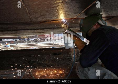 Arbeiter in einer Werft in Dhaka Hafenarbeiter sahen die Reparatur der Schiffe auf dem Pier. Die Schiffbauindustrie in Bangladesch breitet sich rasant aus, Arbeiter aus verschiedenen Teilen des Landes arbeiten am Bau und der Reparatur großer Schiffe, die eine Quelle billiger Arbeitskräfte sind. Am 28. November 2023 in Dhaka, Bangladesch. Wari, Dhaka Bezirk Dhaka Bangladesch Copyright: XHabiburxRahmanx Credit: Imago/Alamy Live News Stockfoto